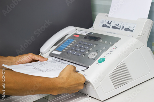 hand man are using a fax machine in the office. Business concept 