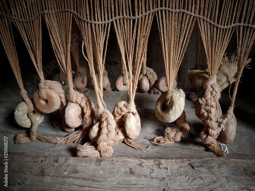 Lines of clay loom weights keep the threads taught on an replica Anglo-Saxon loom.