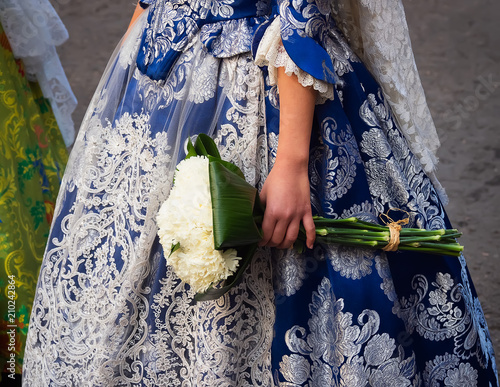 detalle de traje de fallera bordado a mano y ramo de flores que se utiliza para realizar la ofrenda a la Virgen de los Desamparados, en la fiesta de Las Fallas, Valencia, España