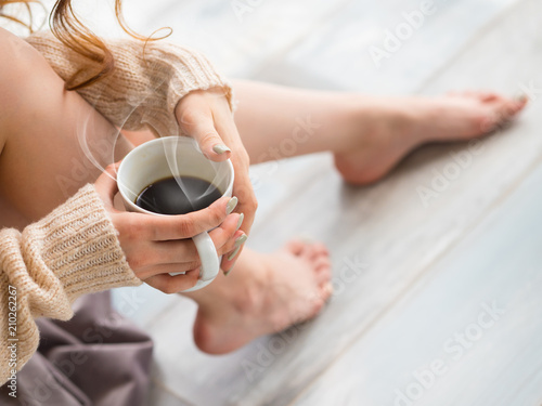 Female feet and a cup of coffee. morning. Awakening