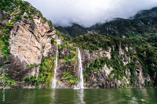 A stunning scene of nature with many waterfalls from the high mountain at Milford Sound, New Zealand.