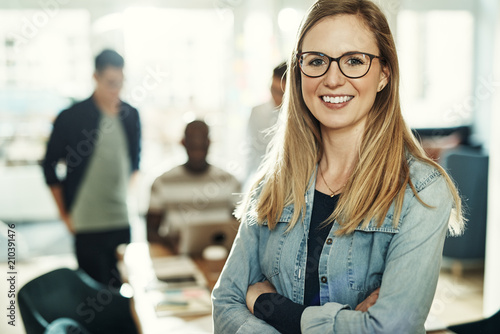 Confident young businesswoman smiling while standing in an office