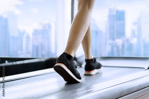 Muscular woman feet running on the treadmill