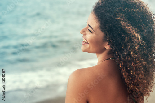 Happy and carefree woman back portrait relaxing near the sea