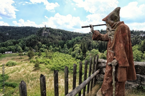 Statue of hermit with the monocular looking to the landscape