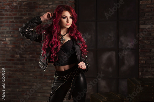 redhead adult girl biker in the leather wear indoor