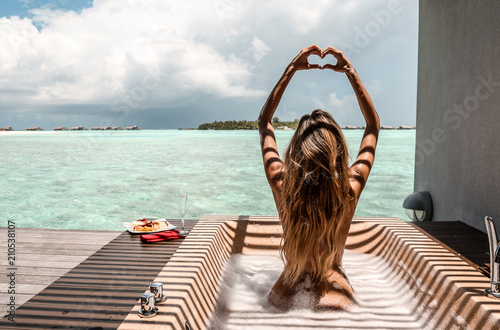 sexy girl with white towel on her body relaxing on Maldive's villa outdoor bathroom