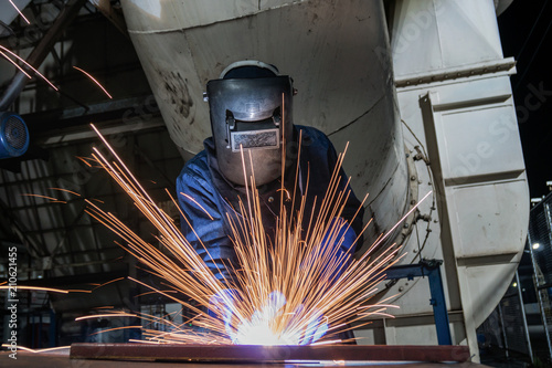 Industrial worker is welding repair steel part