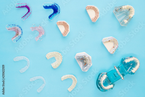 Dental tools and retainer orthodontic appliance on the blue background, flat lay, top vipw.