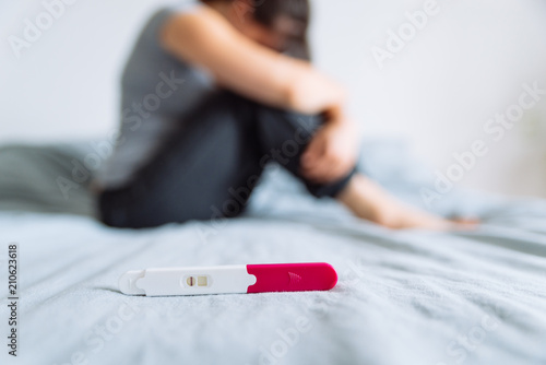negative pregnancy test. sad woman on background