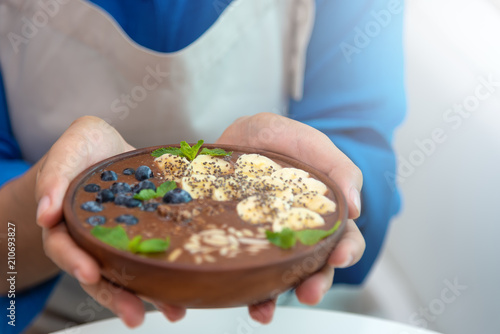 Selected focus on women hand hold a spoon with healthy food on white table. Healthy women eating cereal and fresh fruits for dieting.