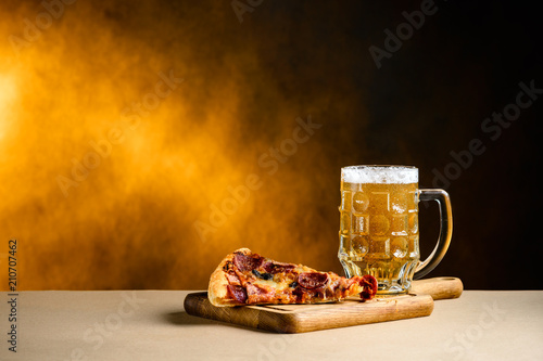 Slice of delicious homemade pizza served with light cold beer on