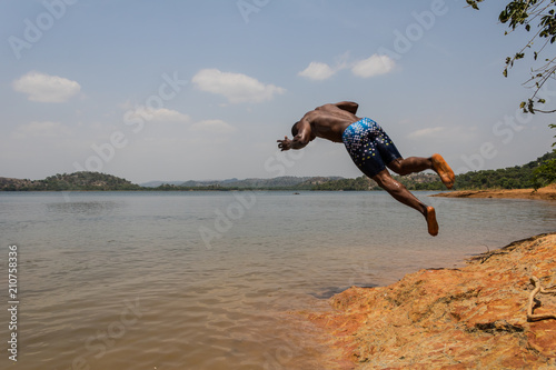 A young male takes a dive into the river in Nigeria, Africa