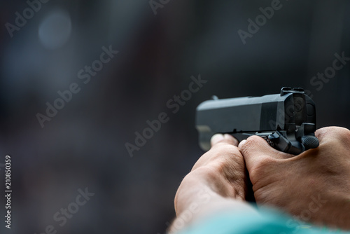 Man aiming gun pistol in shooting range.