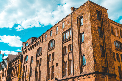 industrial brick building complex with white clouds in the background