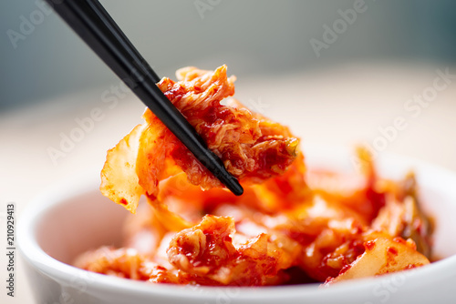 Hand holding chopsticks for eating kimchi cabbage, Korean food