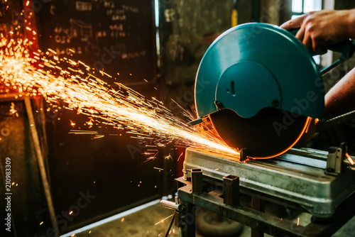 Sparks flying while cutting metal with mitre saw.