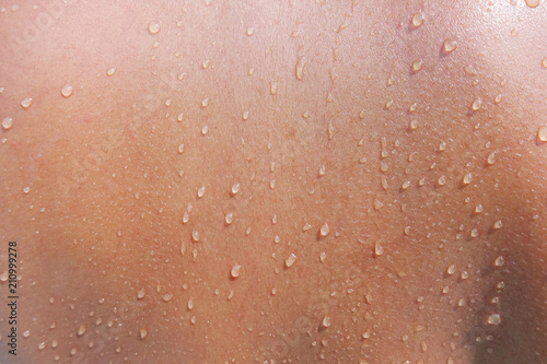 Water drops on woman skin, close up of wet human skin texture 
