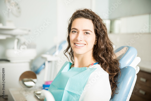 Portrait Of Smiling Young Woman Sitting At Clinic