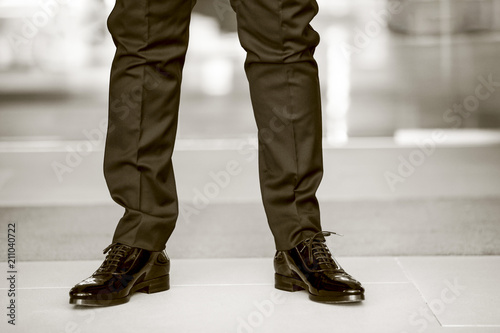 Scarpe nere da uomo con pantaloni neri indossate da una persona