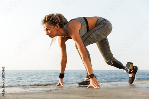 Side view of disabled athlete woman with prosthetic leg