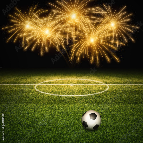 Soccer field with ball against golden fireworks on black background