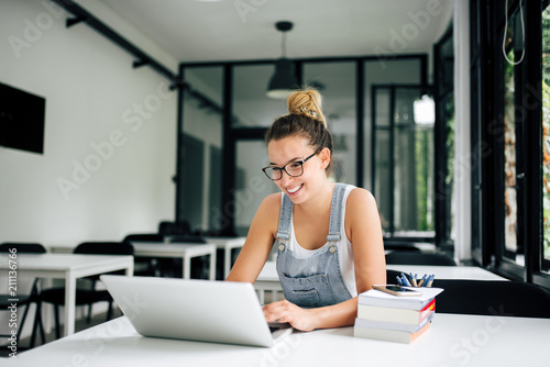 Millennial girl using laptop. Education concept.
