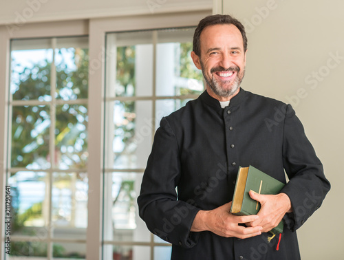 Christian priest man with a happy face standing and smiling with a confident smile showing teeth