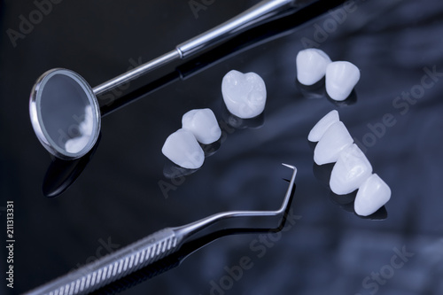Close up dental tools and Tooth implant on a black reflection surface 