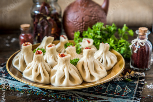 Georgian dumplings Khinkali with meat and red papper, on brown plate