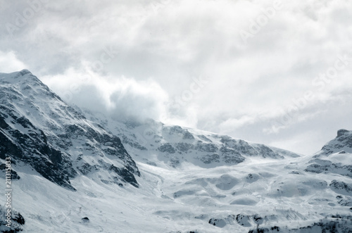 Gigantic blizzard snow storm clouds casting over the mountain peaks