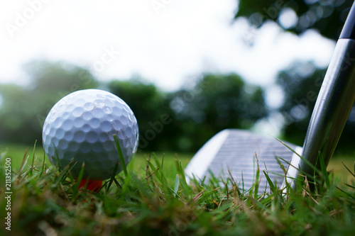 The golf ball and golf club with the warm light of the evening