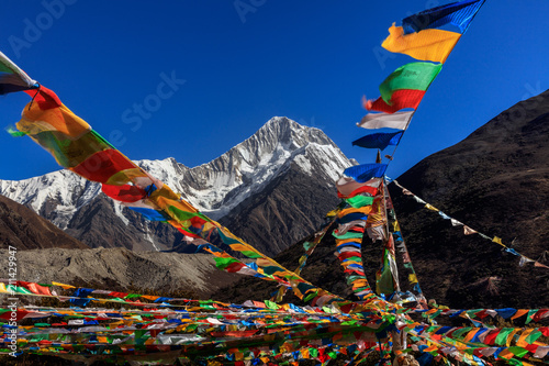 Mount Gongga (also known as Minya Konka) - Gongga Shan in Sichuan Province, China. Tibetan Prayer Flags with Sacred Snow Mountain in the background. Himalayas, Highest Mountain in Sichuan Province