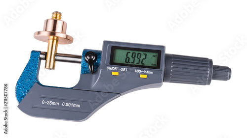 Digital micrometer and shiny metal workpiece. Close-up of measuring a bronze and brass metallic part by the precise gauging device with a green display. Isolated on white background.