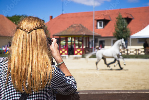 Woman taking picture of horse on horse show