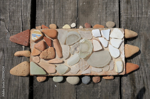 gathered pebbles , stones and pieces of glass from the lake shore