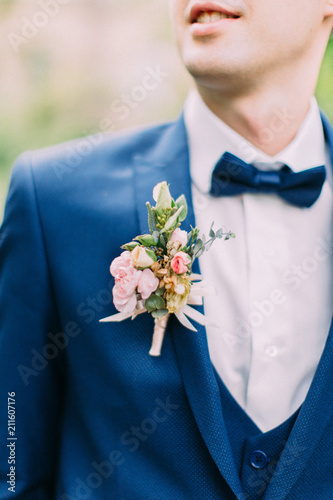 The boutonniere of roses on the jacket of the groom.