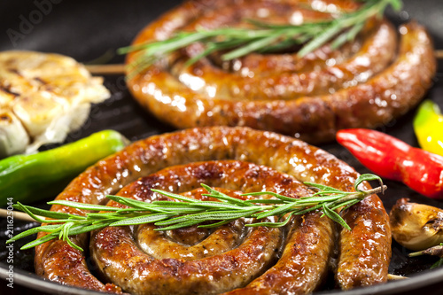 Grilled spiral sausages in a pan