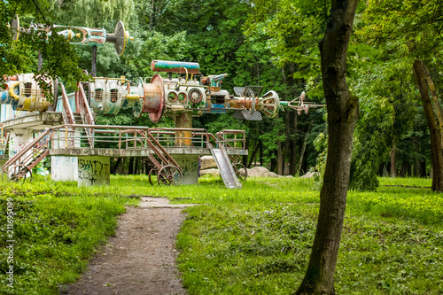 deserted poor old dirty and rusty carousel in outdoor green summer park environment from county of onetime USSR