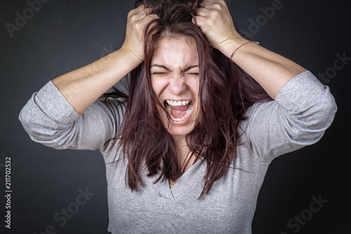 Frustrated angry woman screaming and pulling her hair, young woman angry