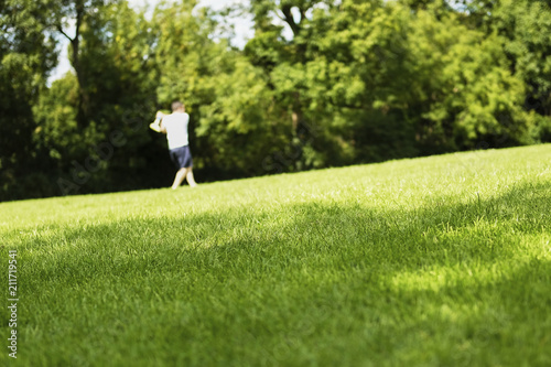 Outline man playing ball and bat in park on green grass. English outdoor activity game