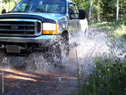 Silver Four Wheel Drive Pick Up Truck Splashing Through Mountain Stream Bed