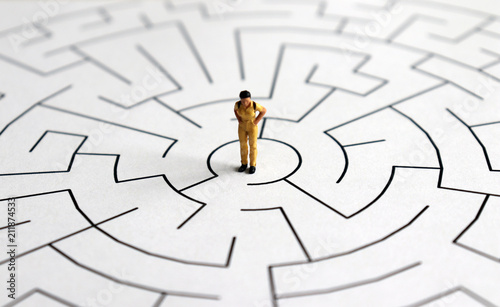 A miniature woman standing in the middle of a maze.