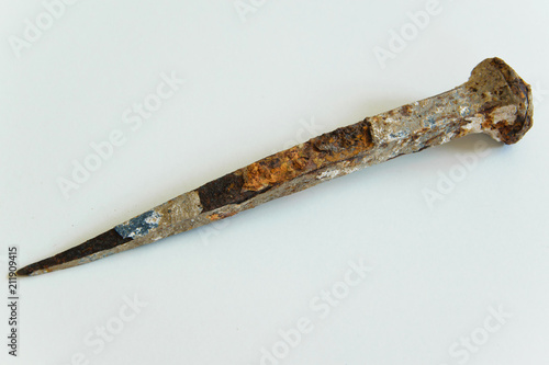 An ancient iron nail on white background