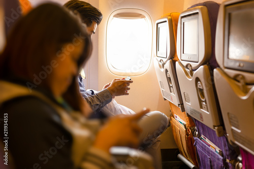 Couple using smartphone in the airplane seat