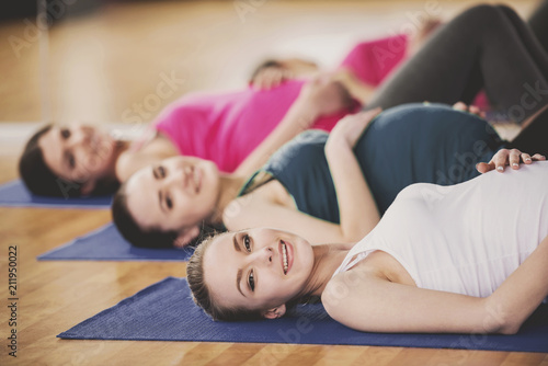 Pregnant Women Doing Exercises on Mats in Gym.