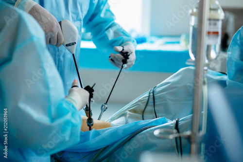 Unrecognizable surgeon's holing the instrument in abdomen of patient. The surgeon's doing laparoscopic surgery in the operating room. Minimally invasive surgery. Close up