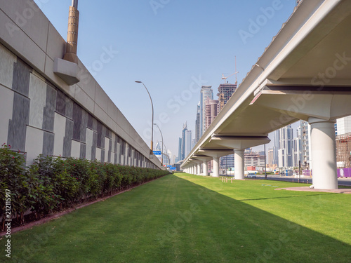 A green flowerbed with grass next to the road on Dubai Street.