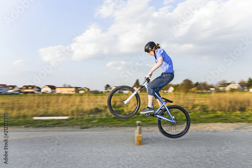 boy jumping with his dirk bike over a barrier at the street