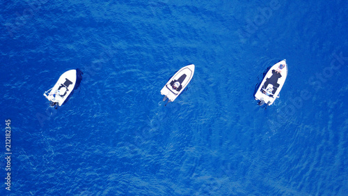 Aerial birds eye view from drone of boats cruising in deep blue sea